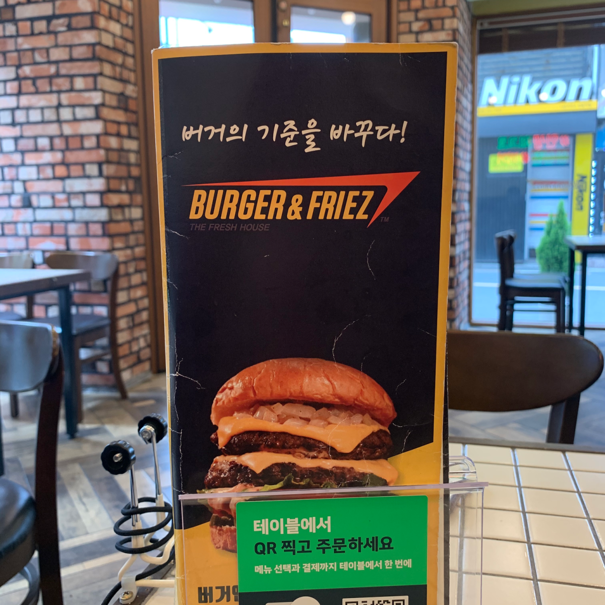 table sign of Burger & Friez with Korean and English text and a picture of a double cheese burger