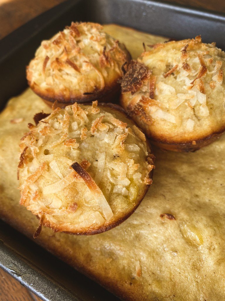 three banana coconut muffins on top of a banana cake